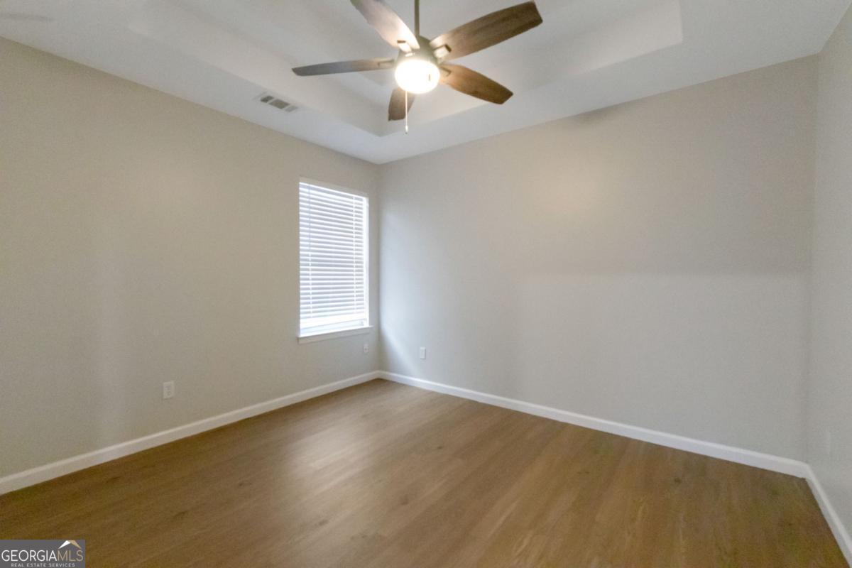 5920 Seabright Lane Atlanta, GA 30349 - Photo 12 of 18 an empty room with wooden floor and windows
