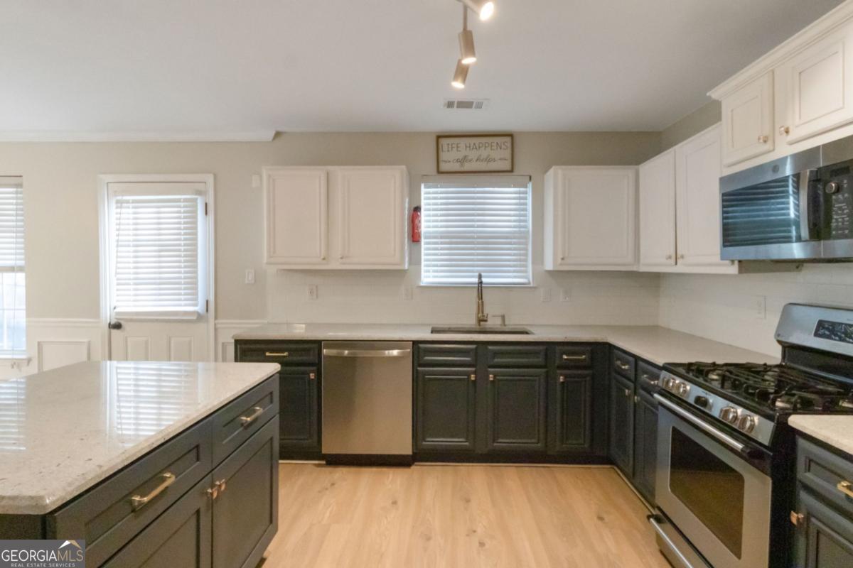 5920 Seabright Lane Atlanta, GA 30349 - Photo 4 of 18 a kitchen with stainless steel appliances granite countertop hardwood floor sink stove and granite counter top