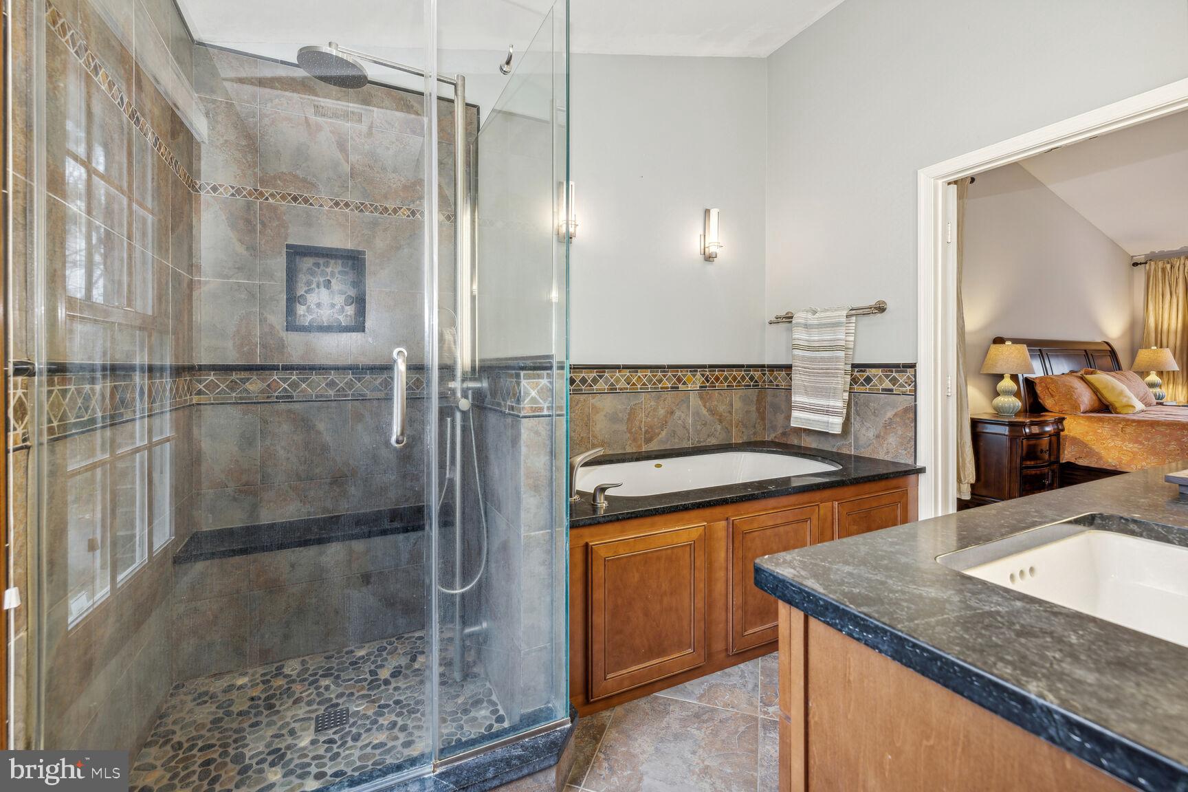 13303 Query Mill Road North Potomac, MD 20878 - Photo 23 of 42 Tiled shower, stone vanity top, specialty lighting