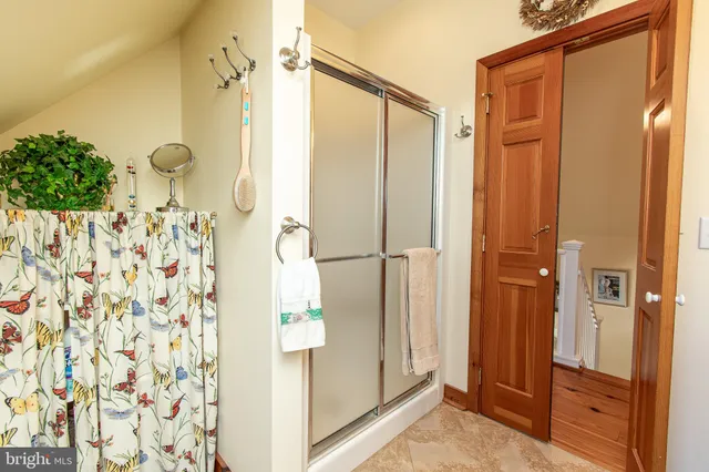 a bathroom with a shower and a glass door