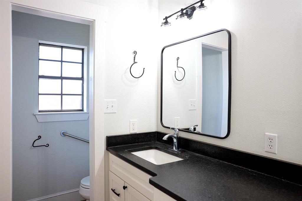 10575 Friendship Road Pilot Point, TX 76258 - Photo 30 of 32 Bathroom vanity featuring a dark countertop with an integrated sink and a chrome faucet