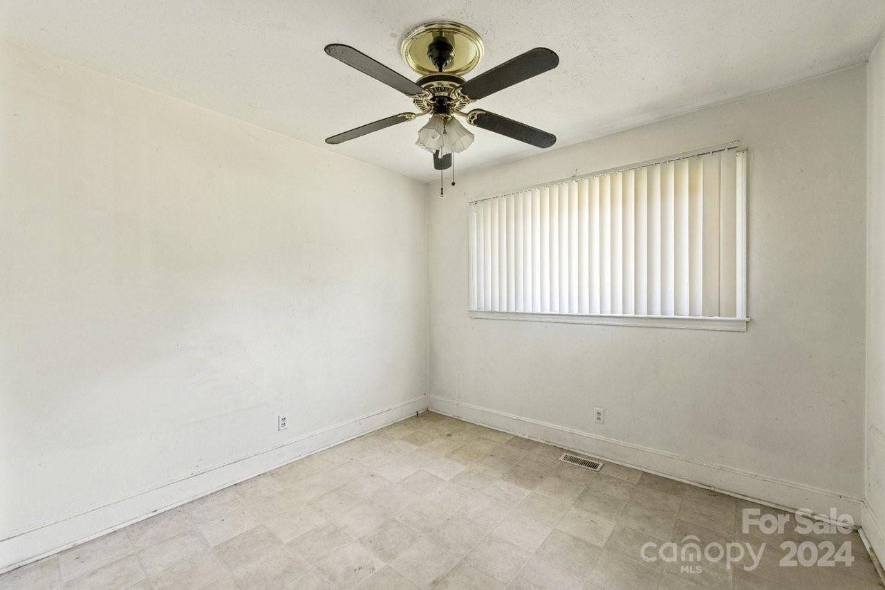 1127 Clanton Road Charlotte, NC 28217 - Photo 11 of 25 an empty room with a window and a fan