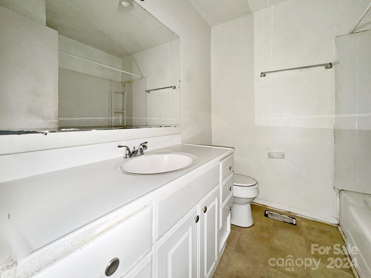 1127 Clanton Road Charlotte, NC 28217 - Photo 14 of 25 a bathroom with a sink and a mirror