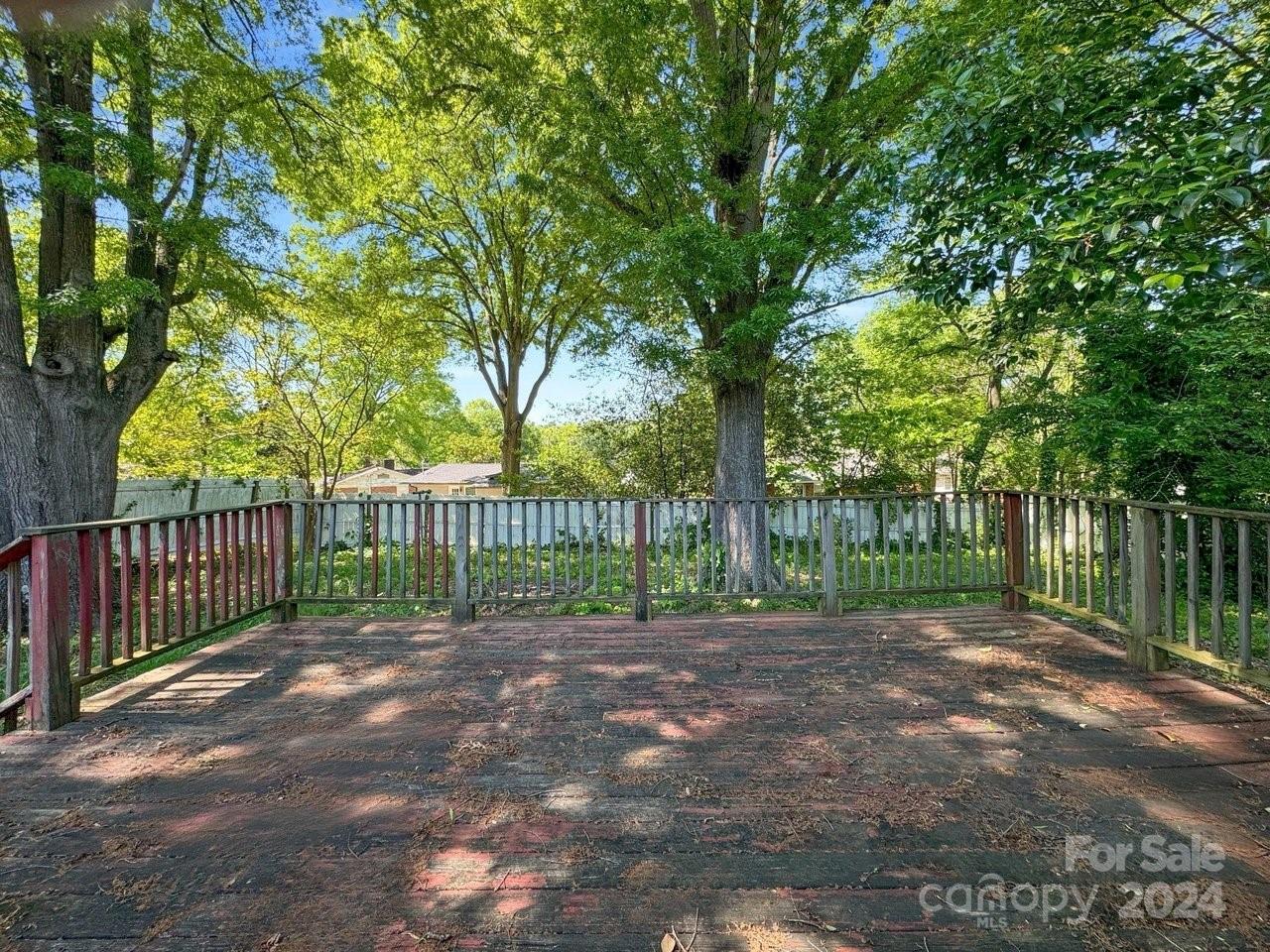 1127 Clanton Road Charlotte, NC 28217 - Photo 19 of 25 a view of a yard with large trees and wooden fence