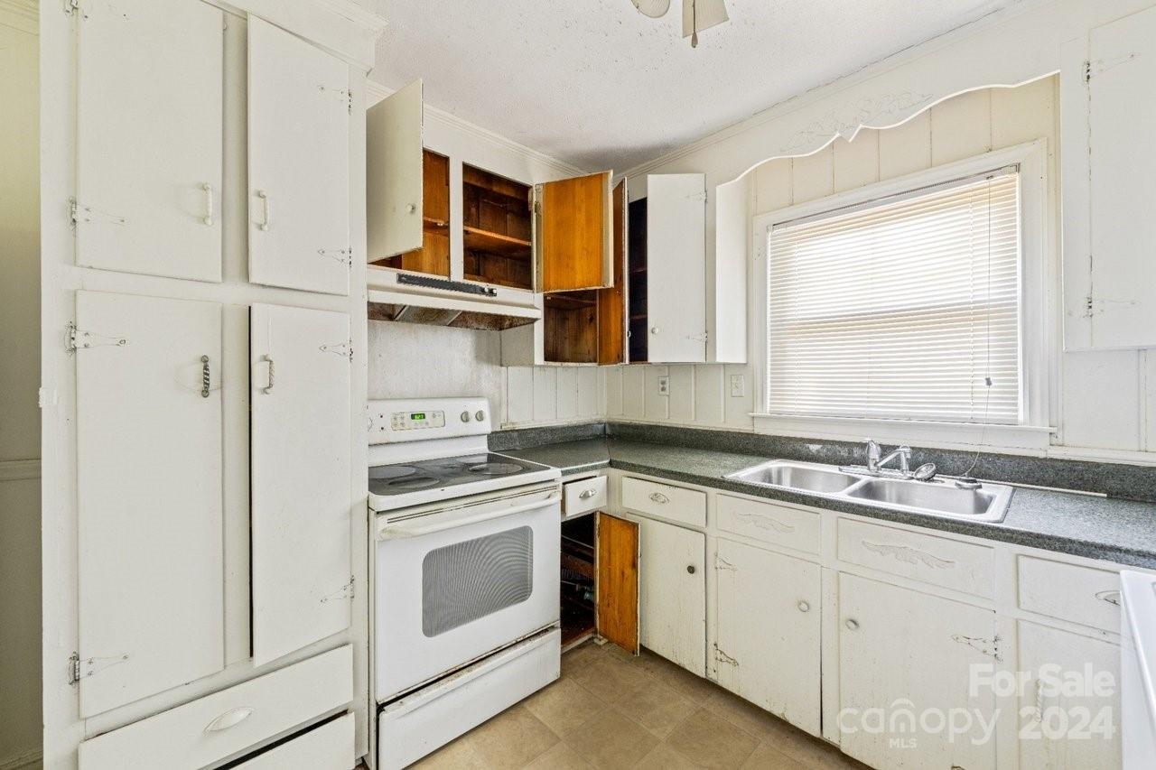 1127 Clanton Road Charlotte, NC 28217 - Photo 6 of 25 a kitchen with stainless steel appliances granite countertop white cabinets and a sink