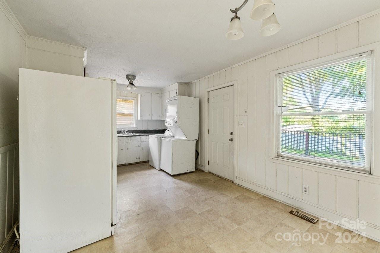 1127 Clanton Road Charlotte, NC 28217 - Photo 9 of 25 a kitchen with a refrigerator a stove top oven and a large window
