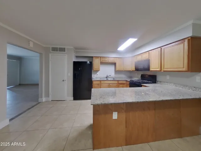 a large kitchen with kitchen island a sink stainless steel appliances and cabinets