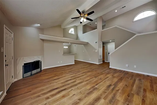 a view of an empty room and a kitchen