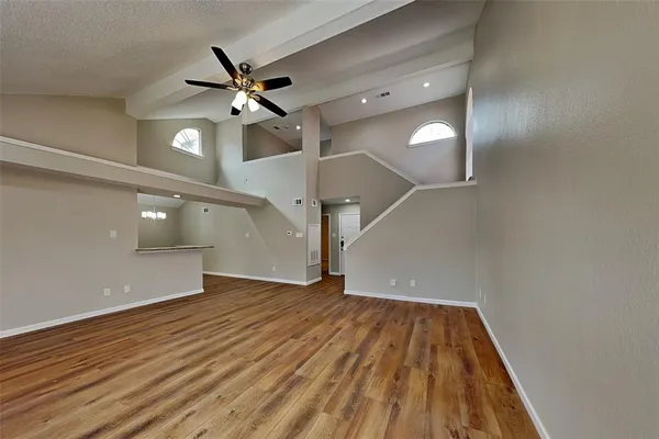 a view of an empty room with wooden floor