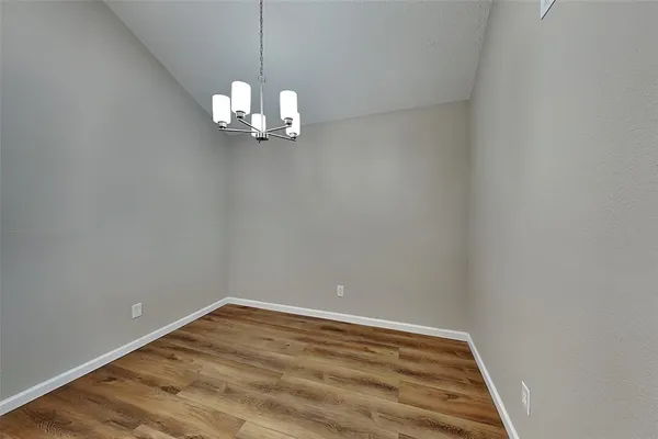 a view of a room with a hanging light and kitchen