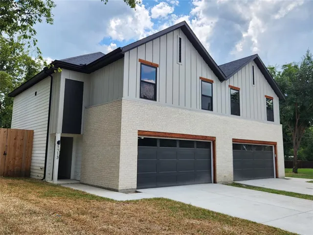 a front view of a house with a garage and a yard