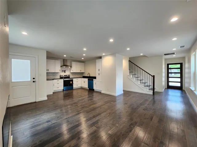 a view of kitchen with kitchen island wooden floor appliances and center island