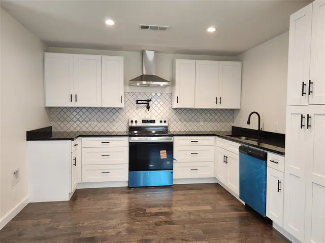 a kitchen with granite countertop white cabinets and white appliances
