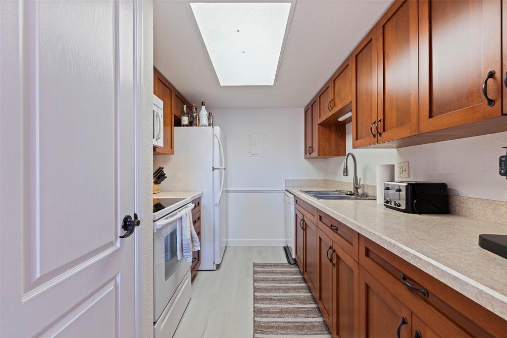 8911 Blind Pass Road, Unit 319 St. Pete Beach, FL 33706 - Photo 13 of 29 a kitchen with a sink and a refrigerator