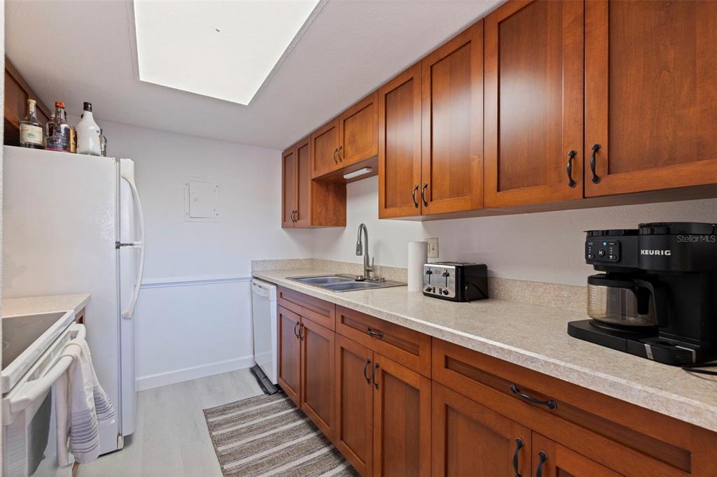 8911 Blind Pass Road, Unit 319 St. Pete Beach, FL 33706 - Photo 14 of 29 a kitchen with stainless steel appliances a stove a refrigerator a sink and dishwasher