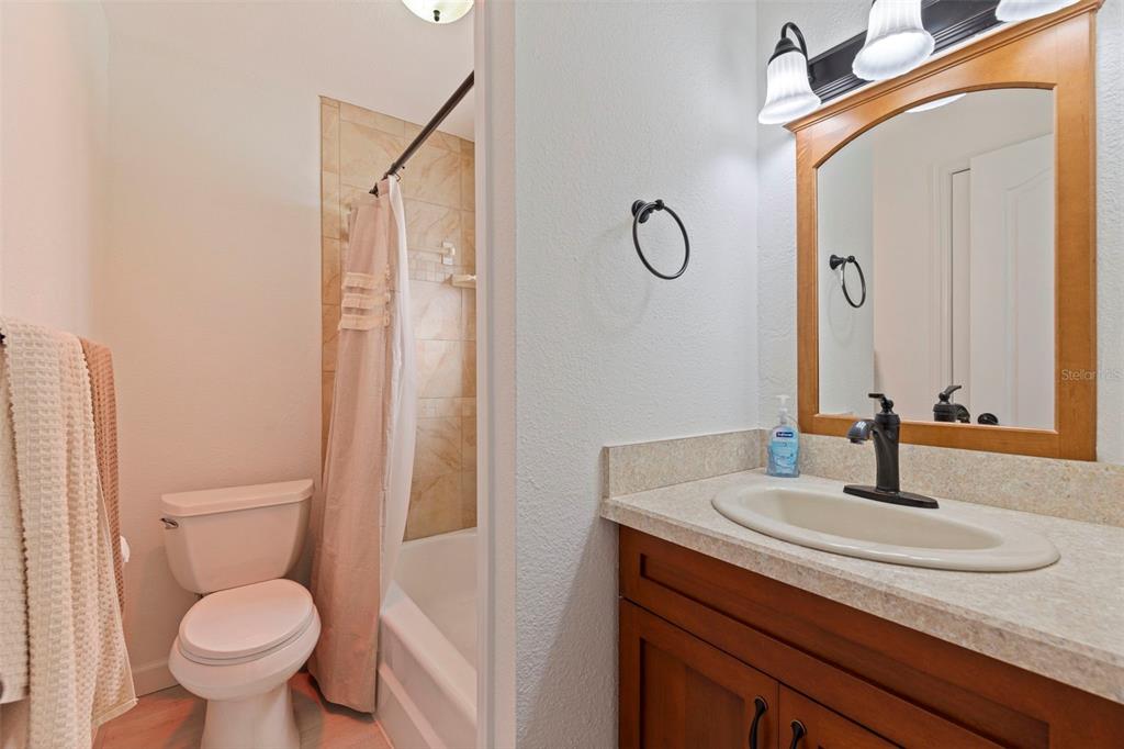 8911 Blind Pass Road, Unit 319 St. Pete Beach, FL 33706 - Photo 19 of 29 a bathroom with a granite countertop sink toilet and mirror