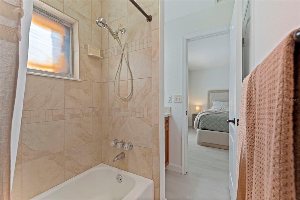 8911 Blind Pass Road, Unit 319 St. Pete Beach, FL 33706 - Photo 20 of 29 a bathroom with a tub shower and a sink