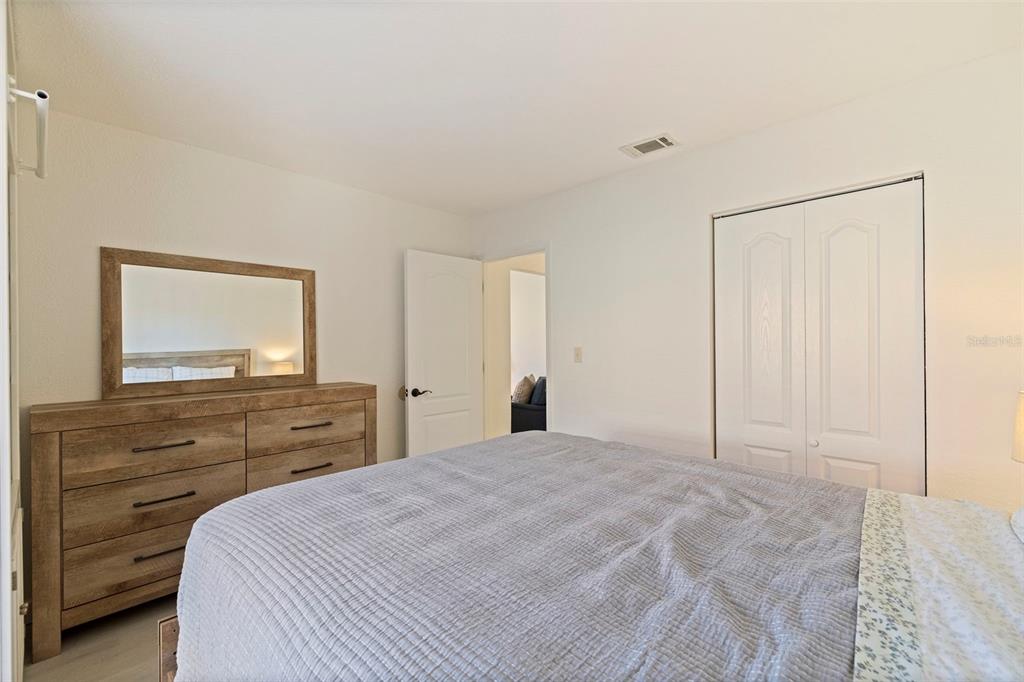 8911 Blind Pass Road, Unit 319 St. Pete Beach, FL 33706 - Photo 22 of 29 a bedroom with a bed and a dresser