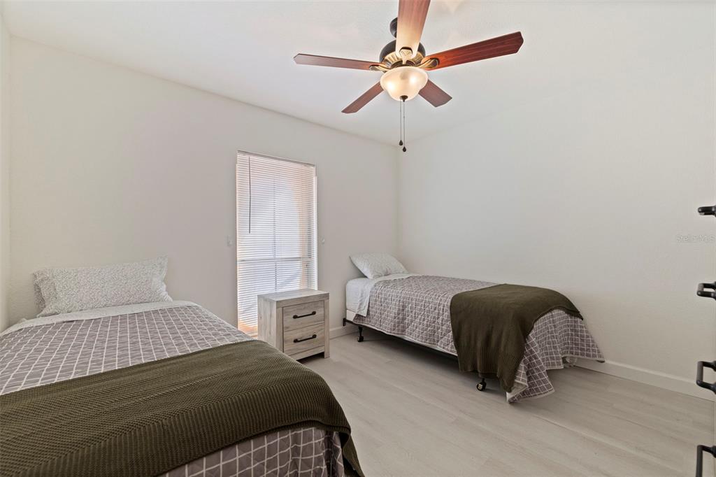 8911 Blind Pass Road, Unit 319 St. Pete Beach, FL 33706 - Photo 24 of 29 a bedroom with a bed chandelier and a window