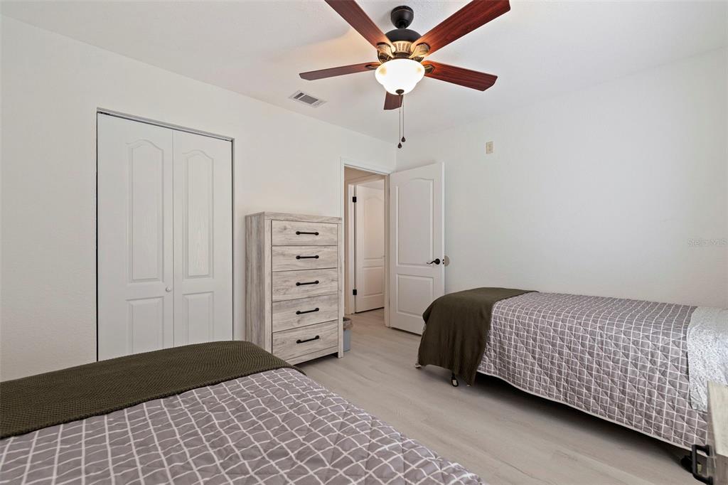 8911 Blind Pass Road, Unit 319 St. Pete Beach, FL 33706 - Photo 25 of 29 a bedroom with a bed and a chandelier