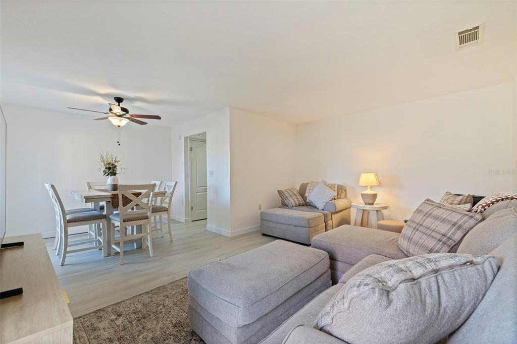8911 Blind Pass Road, Unit 319 St. Pete Beach, FL 33706 - Photo 7 of 29 a living room with furniture and a chandelier