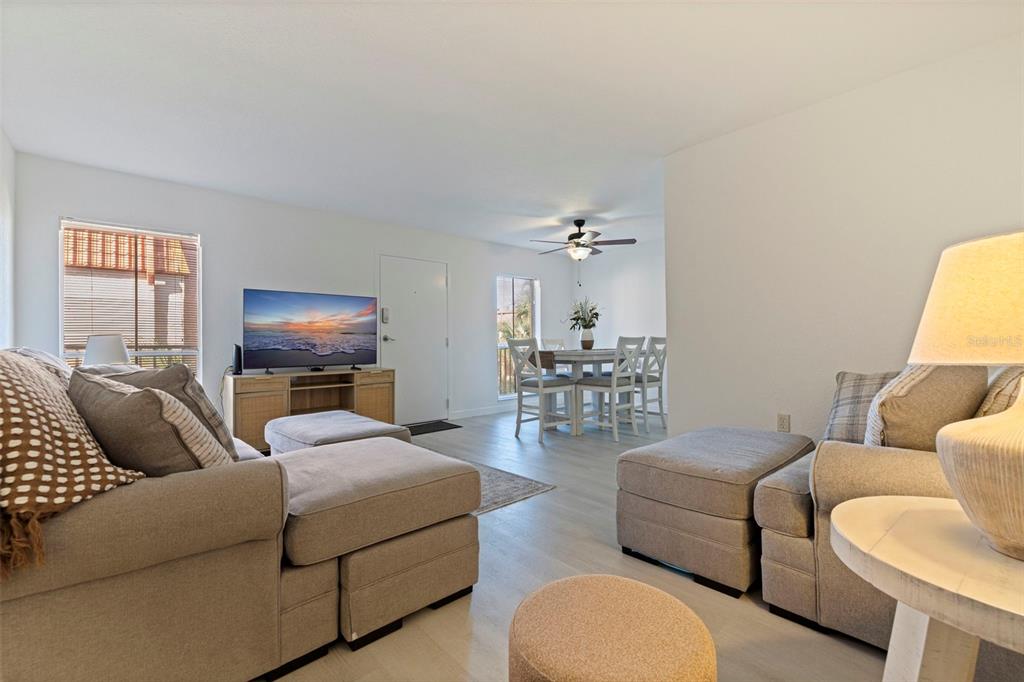 8911 Blind Pass Road, Unit 319 St. Pete Beach, FL 33706 - Photo 8 of 29 a living room with furniture and a flat screen tv