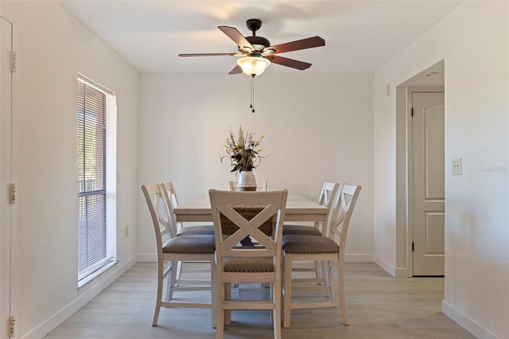8911 Blind Pass Road, Unit 319 St. Pete Beach, FL 33706 - Photo 10 of 29 a dining room with furniture wooden floor and a chandelier