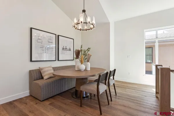 a living room with furniture kitchen view and a chandelier