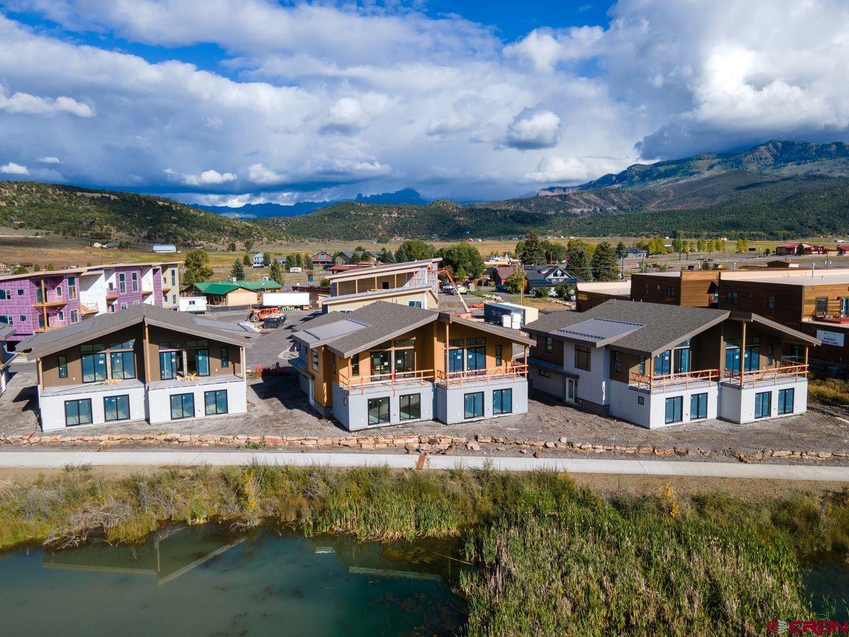 185 Riverfront Lane, Unit D1 B Ridgway, CO 81432 - Photo 4 of 35 a view of a big house with a big yard and large tree