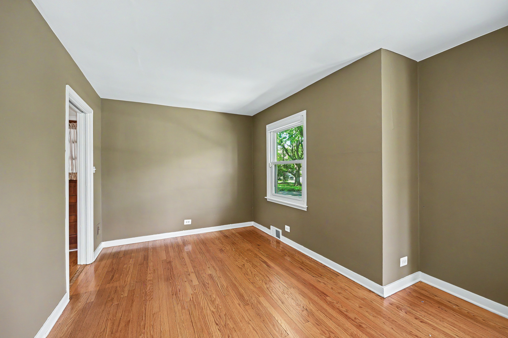 325 South Lambert Road Glen Ellyn, IL 60137 - Photo 13 of 32 a view of an empty room with wooden floor and a window