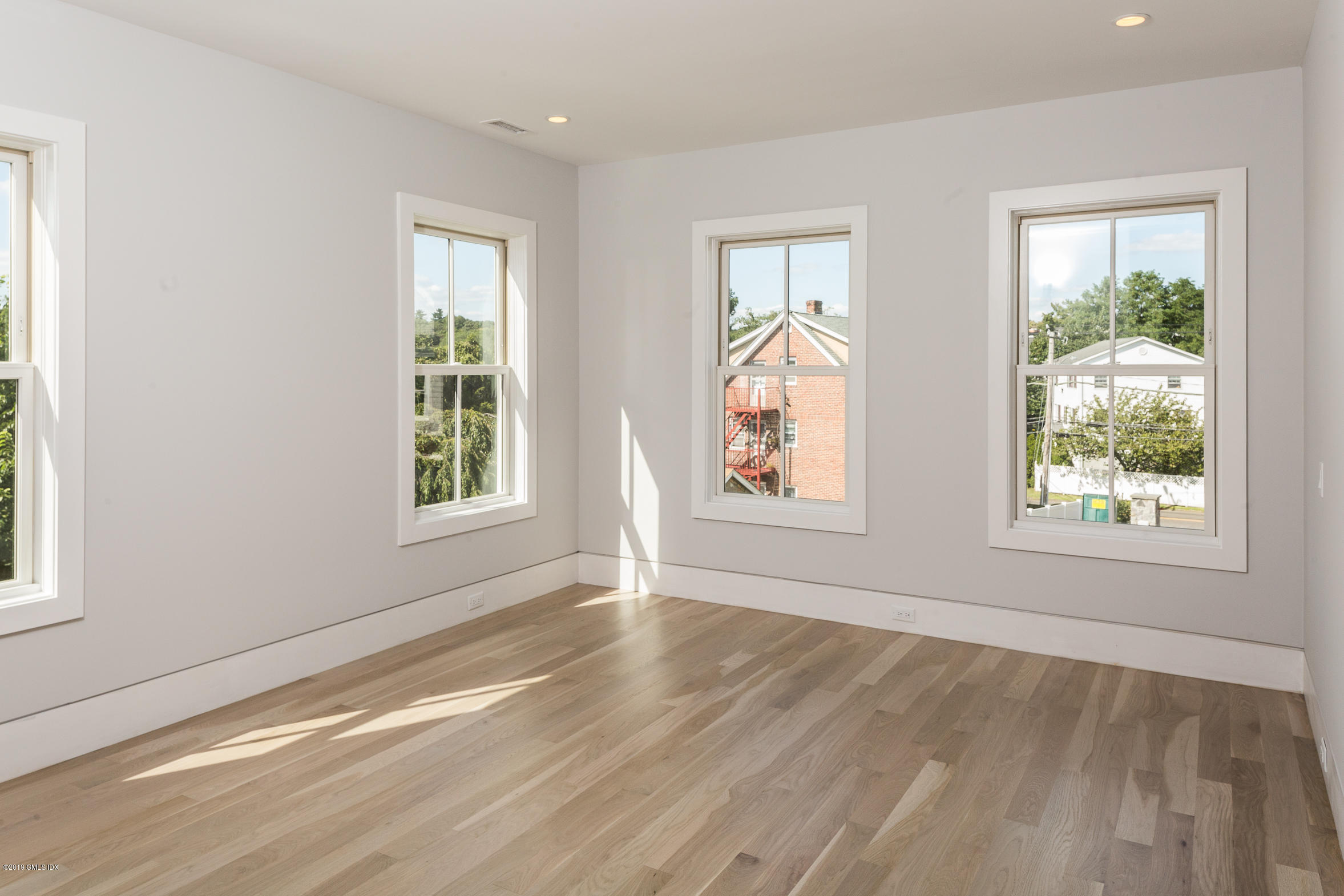 38 St Roch Avenue, Unit E Greenwich, CT 06830 - Photo 12 of 51 a view of an empty room with wooden floor and a window
