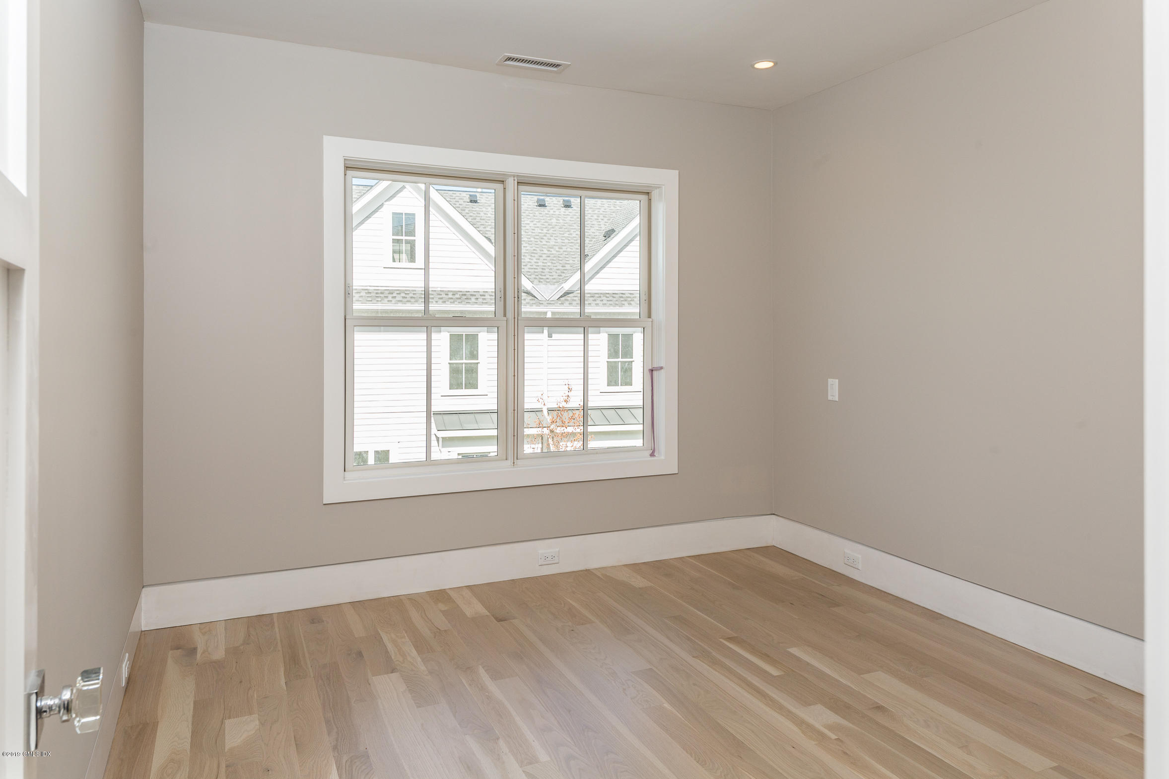 38 St Roch Avenue, Unit E Greenwich, CT 06830 - Photo 14 of 51 an empty room with wooden floor and windows