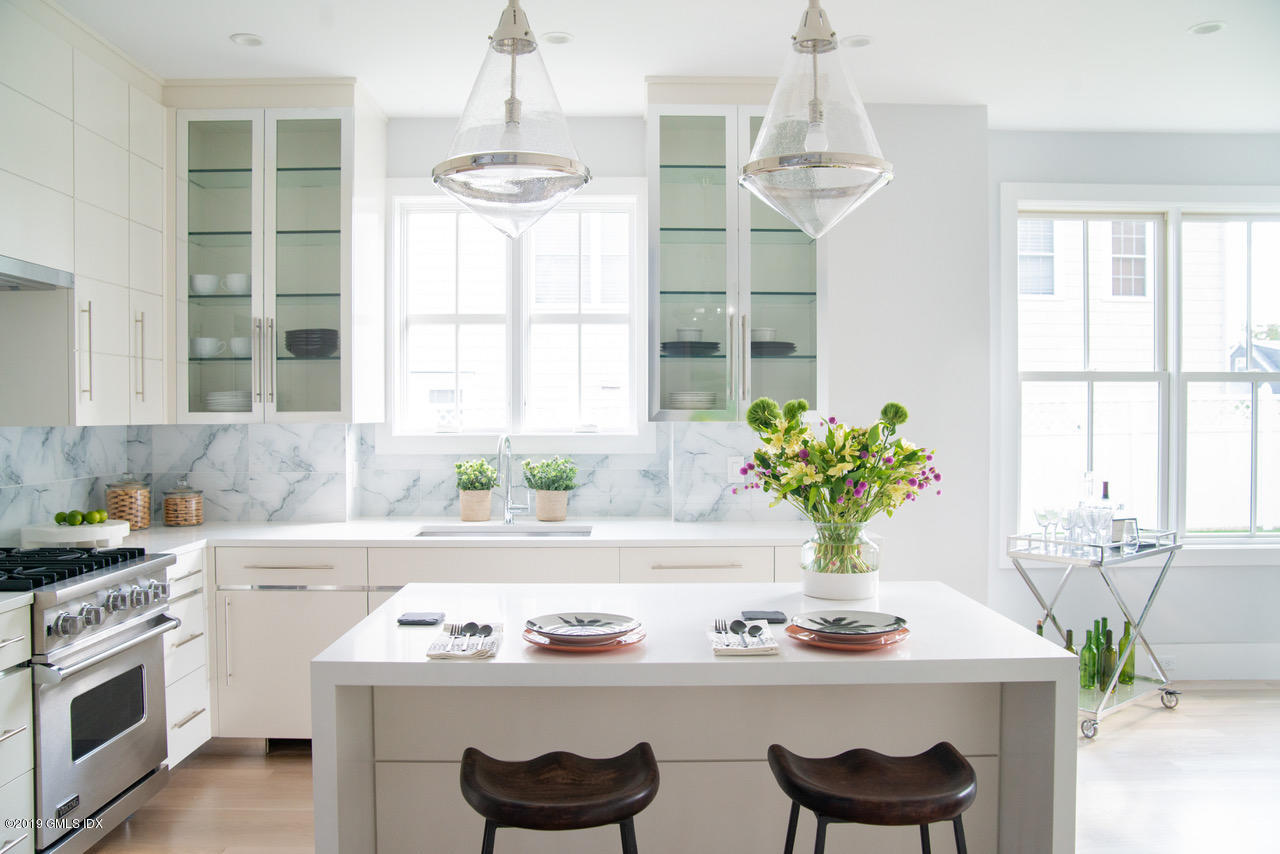 38 St Roch Avenue, Unit E Greenwich, CT 06830 - Photo 2 of 51 a kitchen with a stove a sink and a chandelier