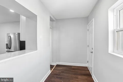 a view of hallway with a fireplace and wooden floor