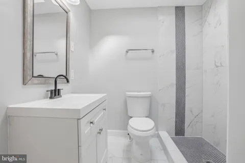 a white toilet sitting next to a bathroom sink