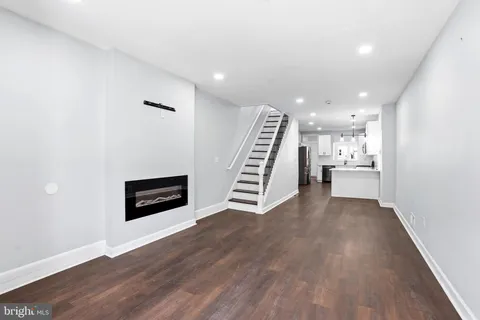 a view of a kitchen with wooden floor and electronic appliances