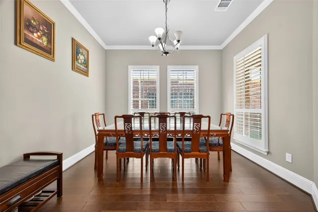 a kitchen with stainless steel appliances granite countertop a table chairs sink refrigerator and cabinets