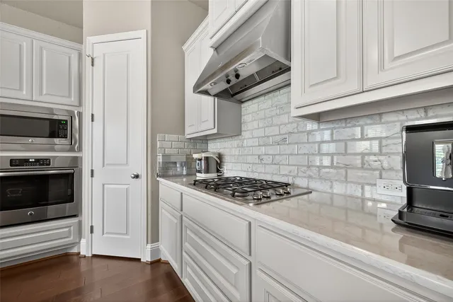 a large white kitchen with a large counter top furniture and appliances