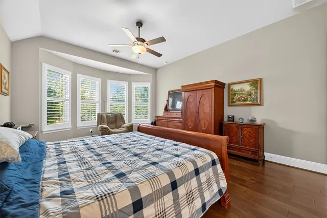 a spacious bathroom with a granite countertop sink a toilet a mirror and shower