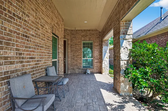 a view of a porch with chairs and potted plants