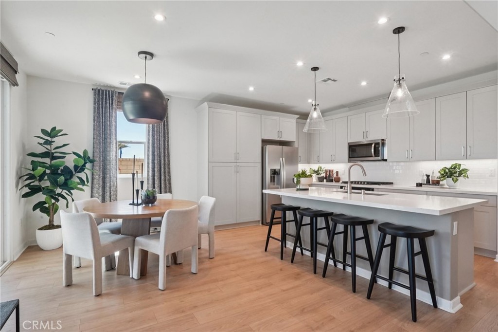 73634 Raphael Drive Palm Desert, CA 92211 - Photo 15 of 42 a kitchen with stainless steel appliances kitchen island granite countertop a dining table chairs and white cabinets
