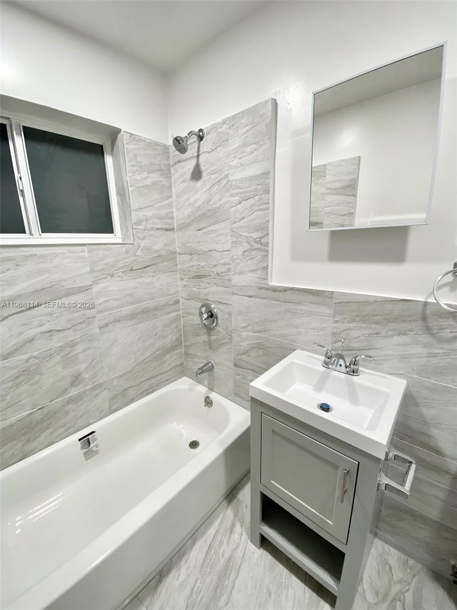 64 Northeast 78th Street, Unit 2 Miami, FL 33138 - Photo 3 of 11 a bathroom with a sink and a bathtub