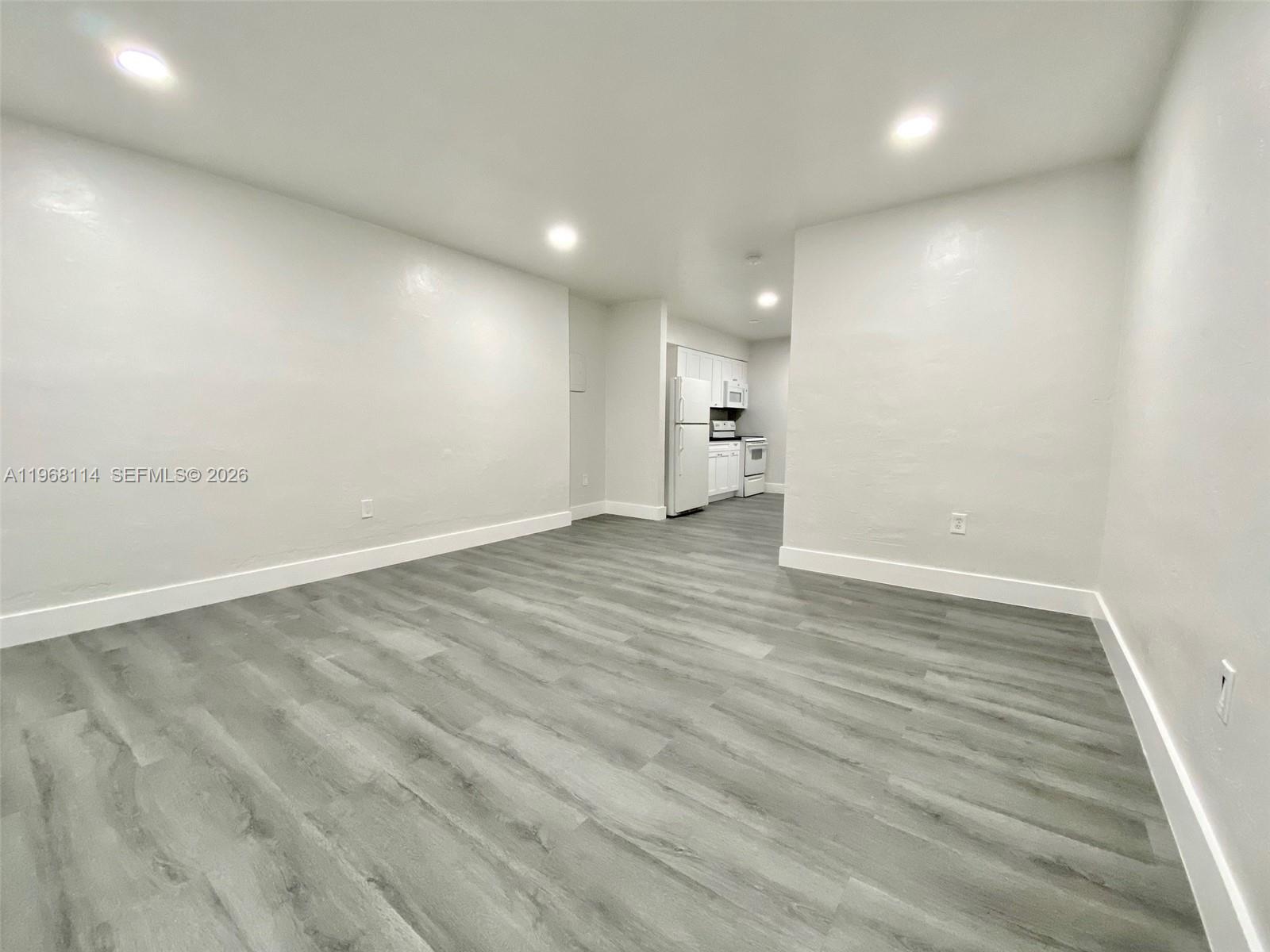 64 Northeast 78th Street, Unit 2 Miami, FL 33138 - Photo 10 of 11 an empty room with wooden floor and windows