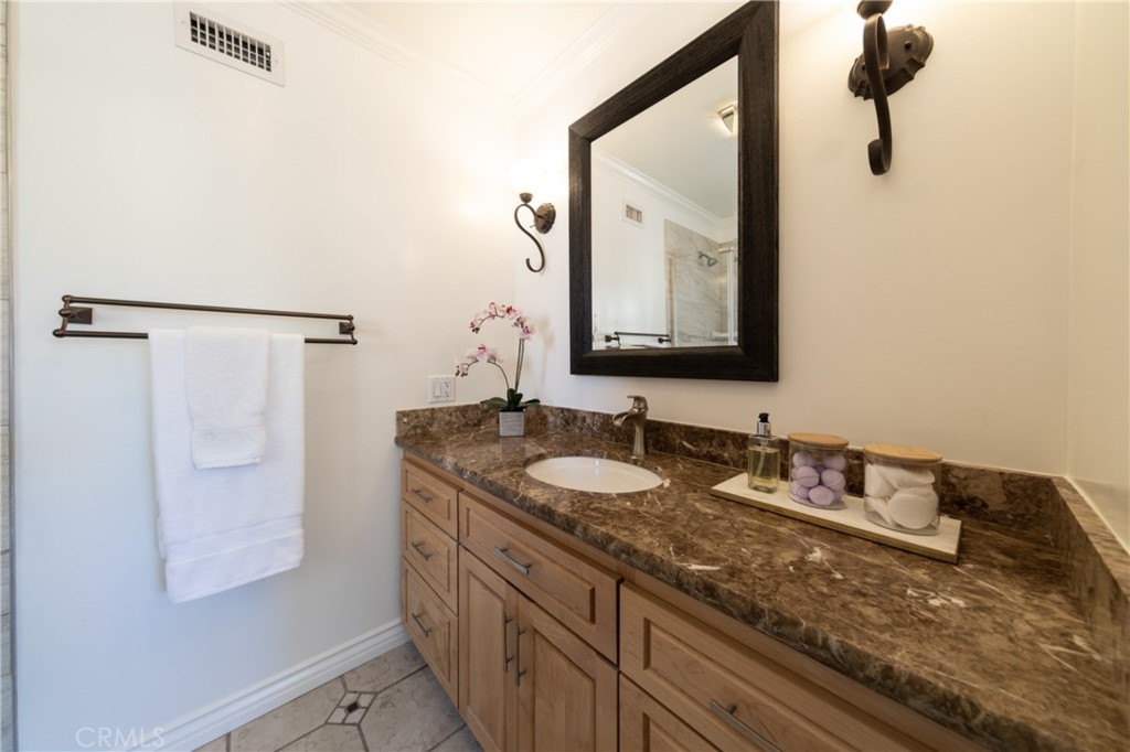 28009 Newbird Drive Saugus, CA 91350 - Photo 15 of 26 a bathroom with a granite countertop sink a mirror and shower