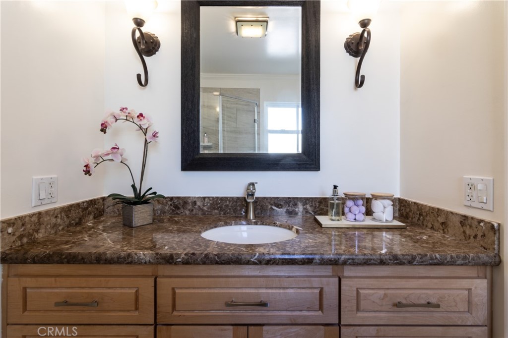 28009 Newbird Drive Saugus, CA 91350 - Photo 17 of 26 a bathroom with a granite countertop sink and mirror