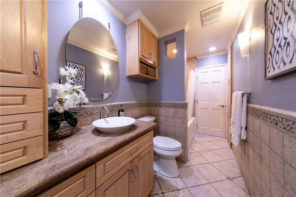 28009 Newbird Drive Saugus, CA 91350 - Photo 20 of 26 a bathroom with a granite countertop sink a toilet a mirror and shower