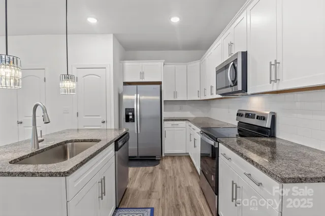 a kitchen with stainless steel appliances granite countertop a sink stove and refrigerator