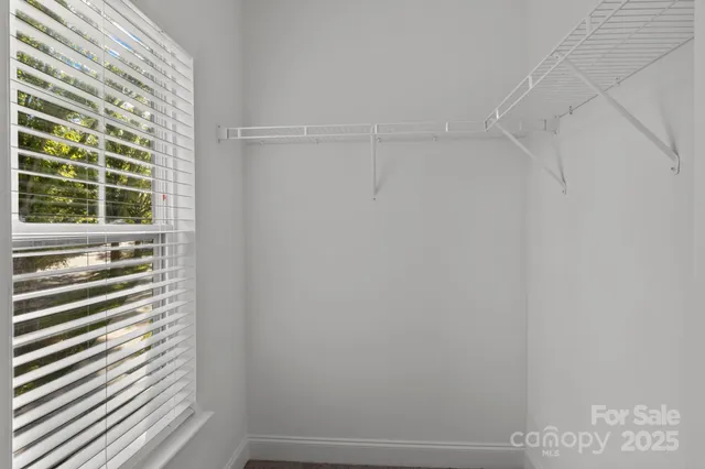 a view of a closet area with wooden floor