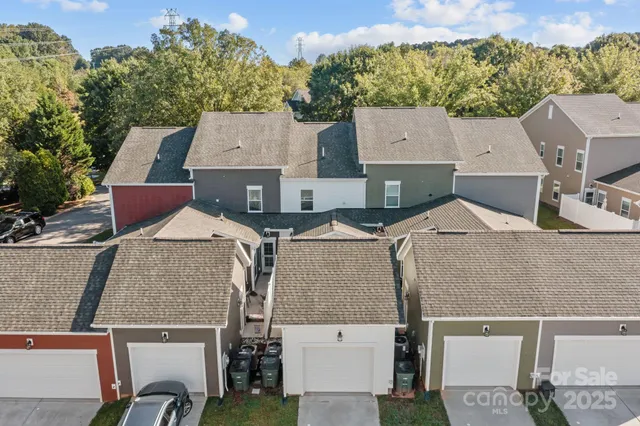 an aerial view of residential houses with outdoor space and parking