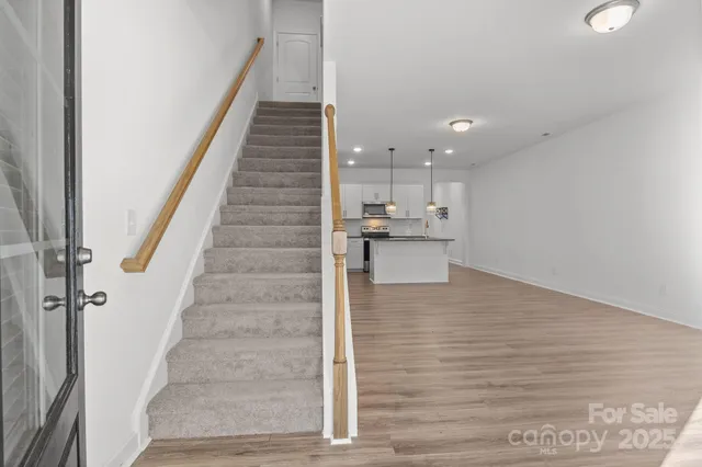 a view of a kitchen with stairs and wooden floor